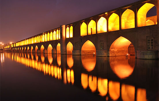 Well-lit building with arched windows on the water